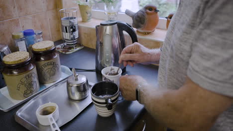 man making tea in a kitchen