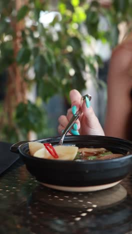 woman eating soup with dumplings