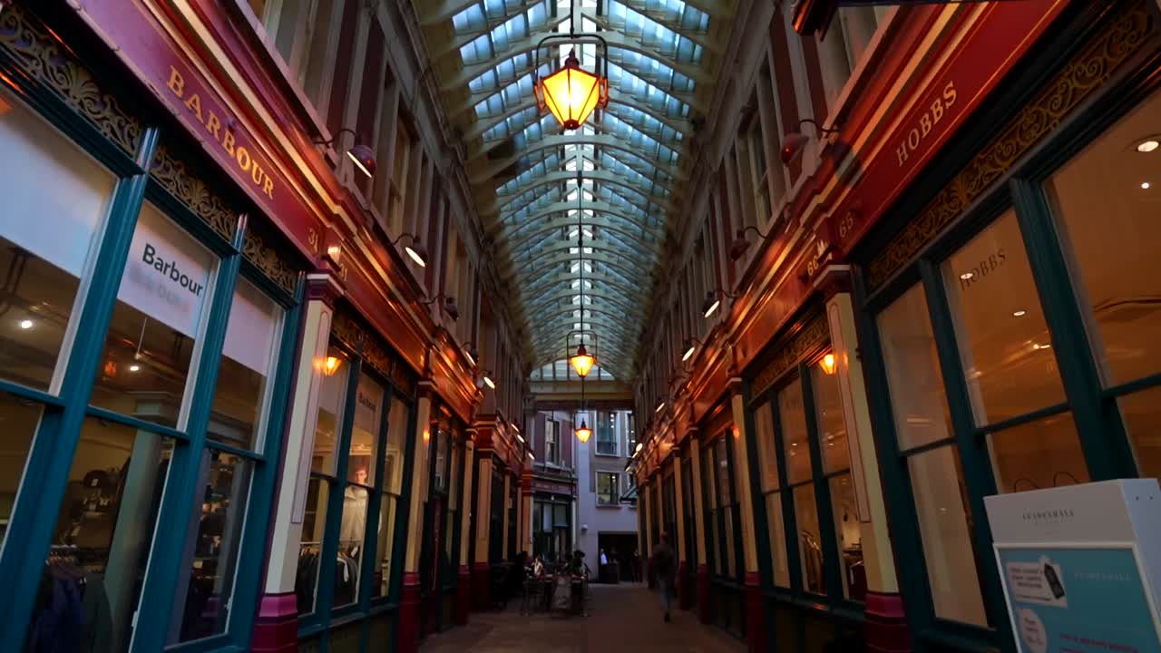 Night view of a covered walkway in London with shops and people