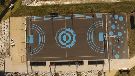 flying over a basketball field vertical view sunny day