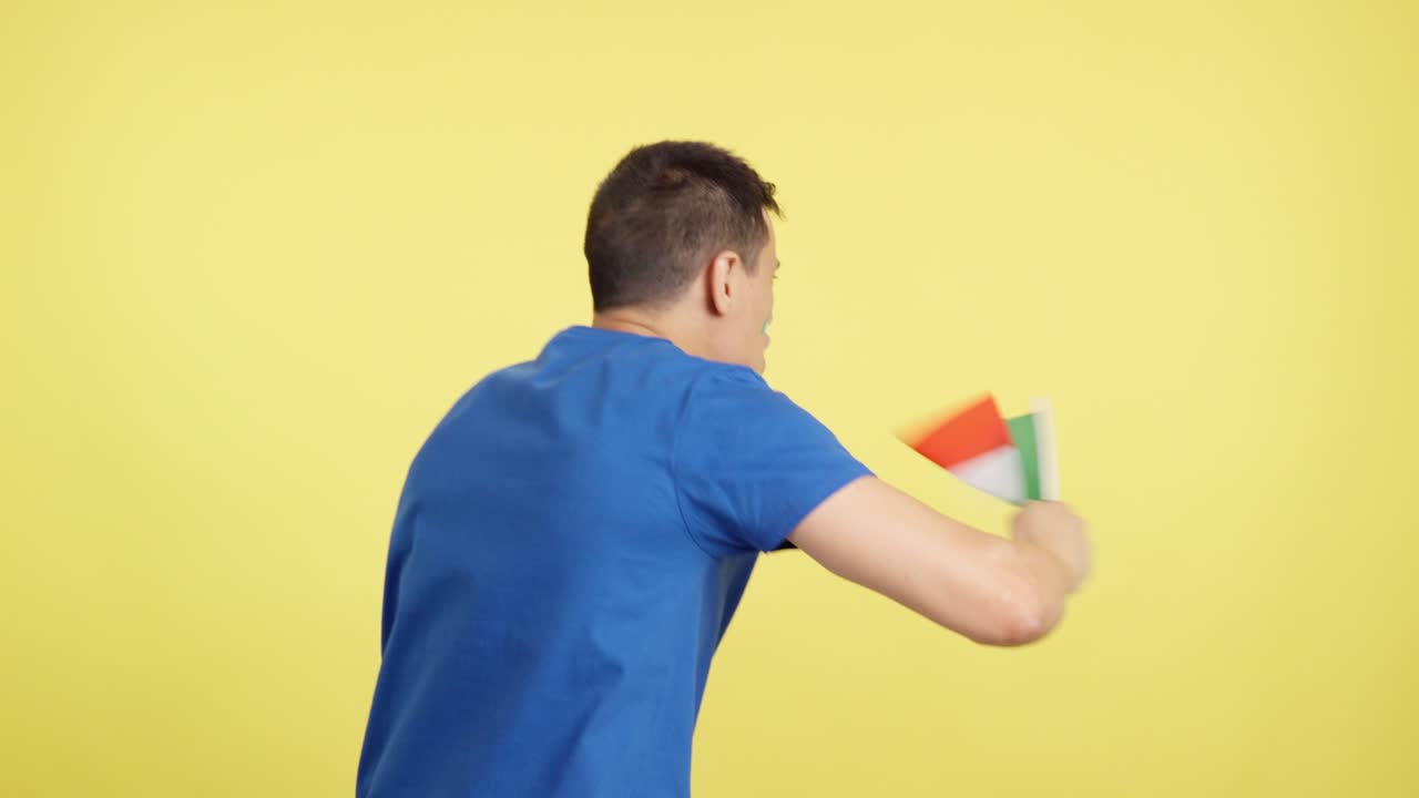Rear view of a man waving a italian pennant