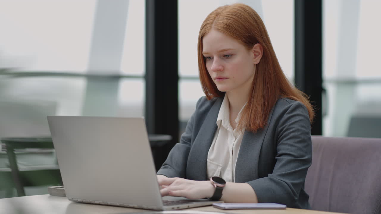 Pretty student woman using laptop in outdoors cafe while having cup of coffee. Cheerful woman working at cafe on laptop. Businesswoman working during layover at modern airport.