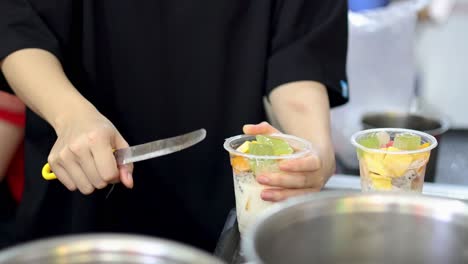 manos preparando un postre de frutas mixtas