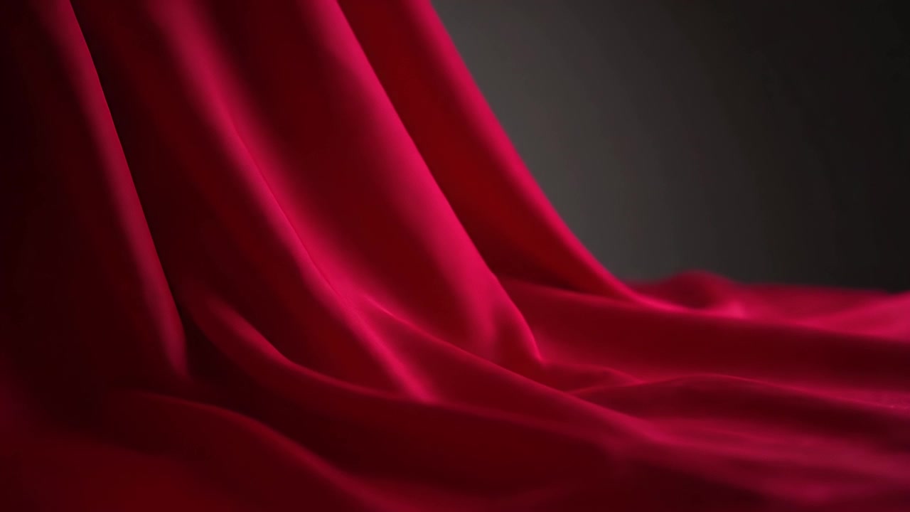 Flowing Red Silk Fabric Against Dark Background
