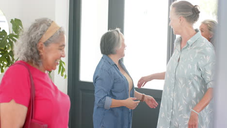 Senior-biracial-woman-in-a-pink-top-shares-a-laugh-with-a-Caucasian-woman-in-a-patterned-shirt