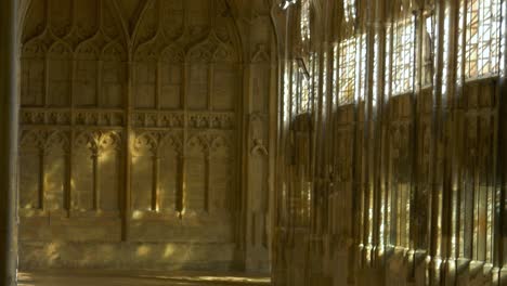 sunlight at empty cloister with fan vaulted ceiling of gloucester cathedral in gloucester, england, uk