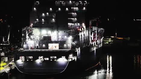 a-navy-ship-tied-up-to-a-dock-in-the-dark