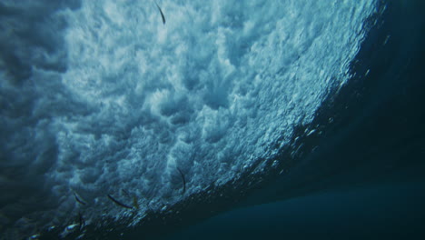 view from backside of strong ocean wave barrel spinning into curl with sparkling water pattern