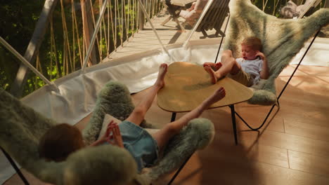 children sit in furry chairs in glamping cabin. yawning boy and sister enjoy lazy afternoon on shady hotel terrace. little kids at low table