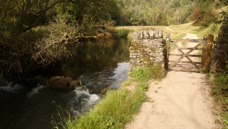 wide shot of a gate midway through the dovedale walk with the river dove on the left hand side