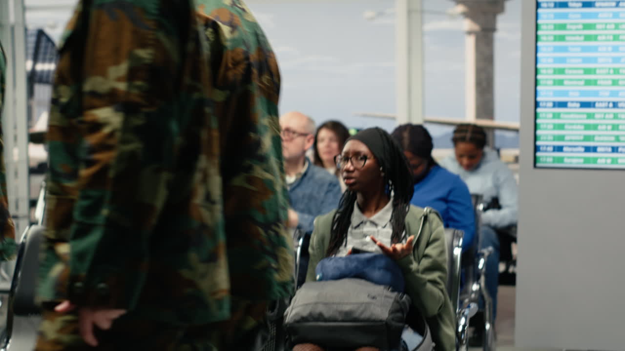 Women curious about army troops presence in airport terminal, taking pictures