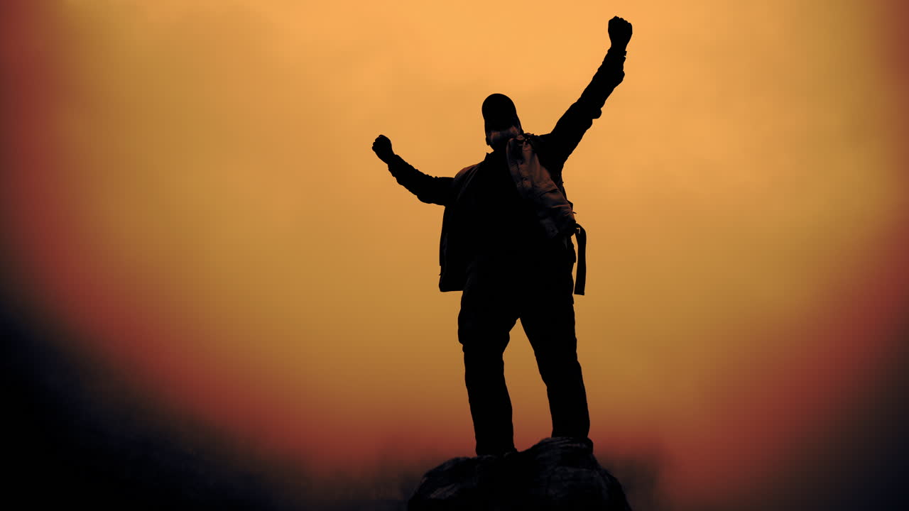 Silhouette of a successful man celebrating at sunset