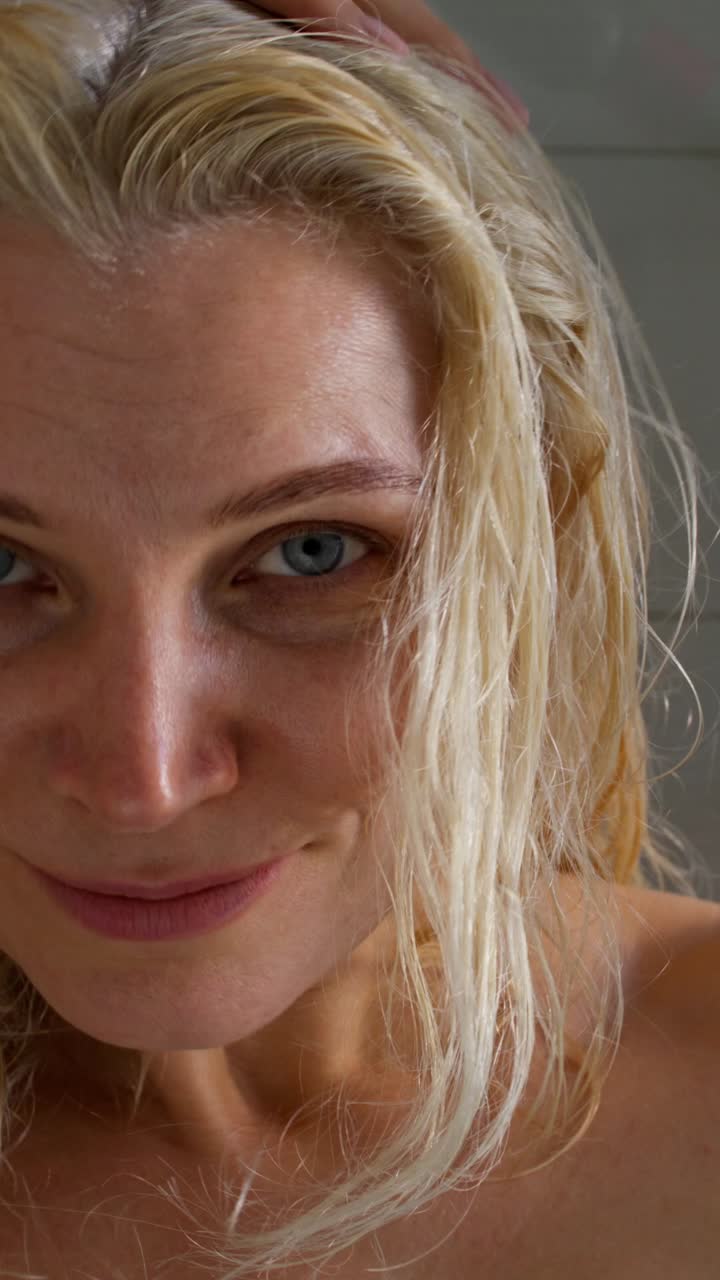 mujer secándose el cabello en el baño