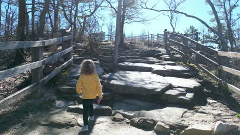 Toddler-Hiking-up-mountain-behind-mother,-pilot-mountain,-Mount-Airy-North-Carolina