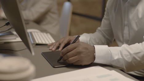 close up of american male hands drawing on a graphics tablet in the office