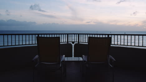 Tumbonas-Vacías-Frente-A-La-Bahía-De-Waikiki-Y-La-Línea-Del-Horizonte-Al-Amanecer,-Vista-Desde-El-Balcón,-Hawaii