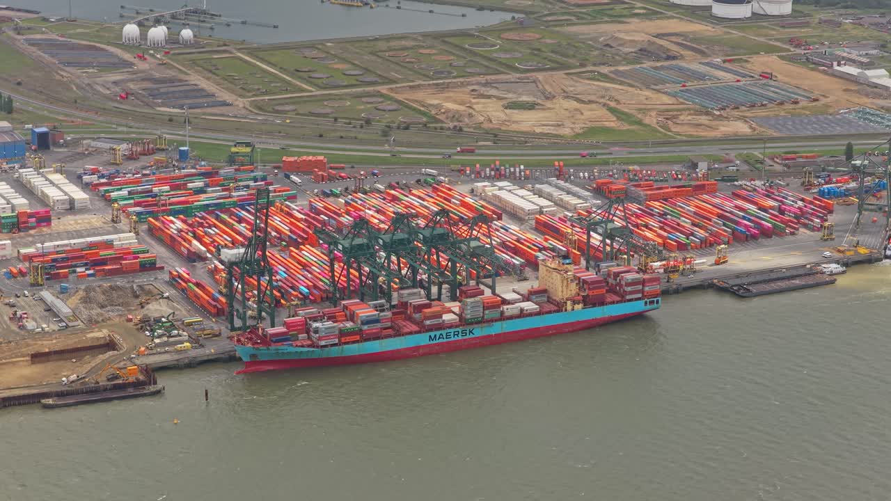 Aerial drone view of container port terminal with cargo vessels and cranes