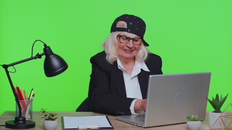 Senior-business-woman-raises-thumbs-up,-agrees,-approve,-likes-good-news-using-laptop-at-office