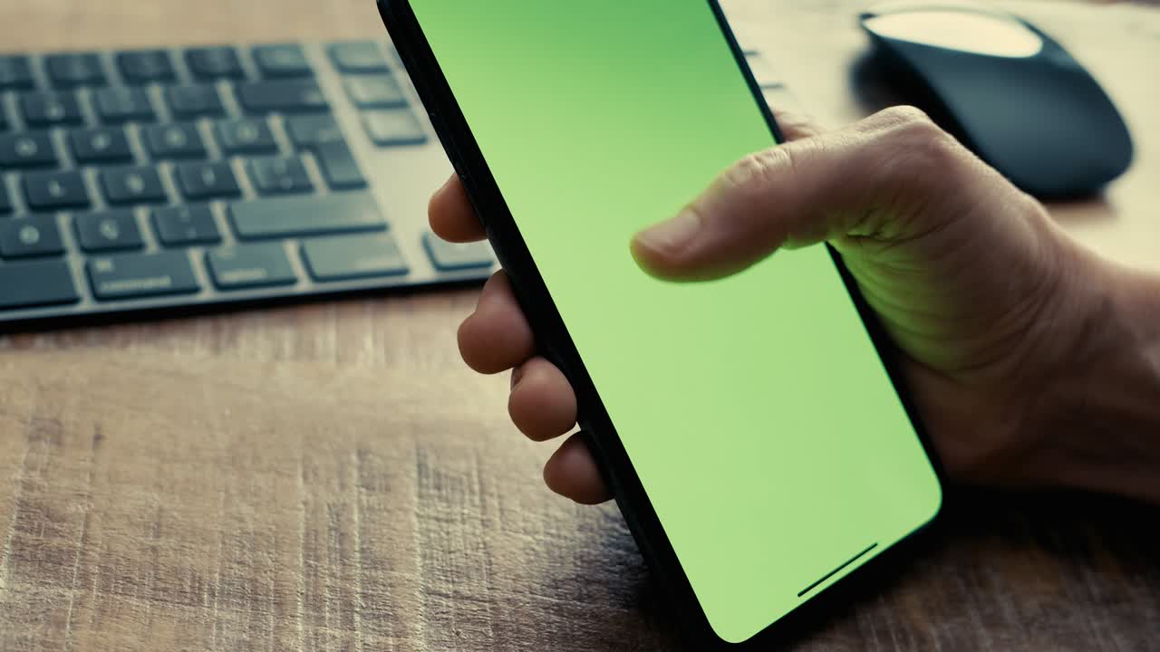 manos usando teléfono móvil con pantalla verde