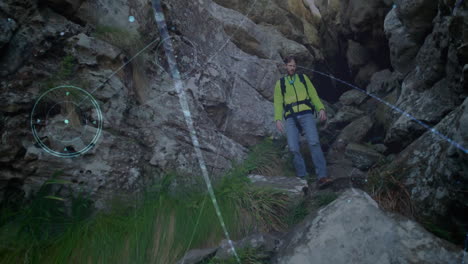 male hiker descending rocky mountain pass, under digital navigation overlay for outdoor technology