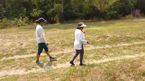 A-Blind-Woman-Walks-With-A-Cane-Through-A-Natural-Area-With-A-Guide-Helping-Her-Explore-The-Wilderness-7