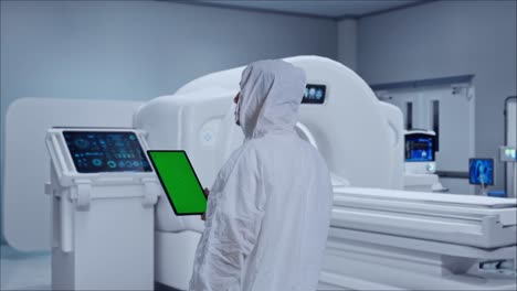 back view of asian male scientist use green screen tablet while standing with mri machine in the hospital