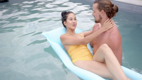 Una-Joven-Pareja-Birracial-Disfruta-Del-Tiempo-En-Una-Piscina,-Copia-Espacio