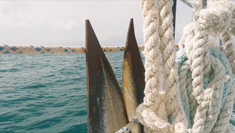 Closeup-detail-of-anchor-on-board-of-moving-sailboat,-sea-scenery,-day