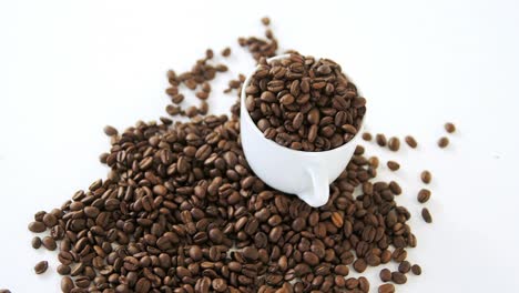 cup of coffee filled with roasted coffee beans