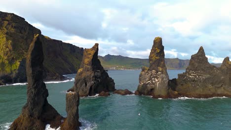 aerial orbiting shot of the reynisdrangar basalt rocks off the coast of iceland