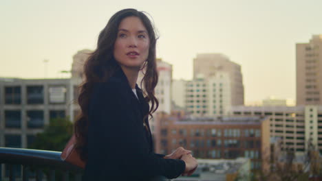 portrait of asian woman enjoy city view near railings. lady waiting date closeup