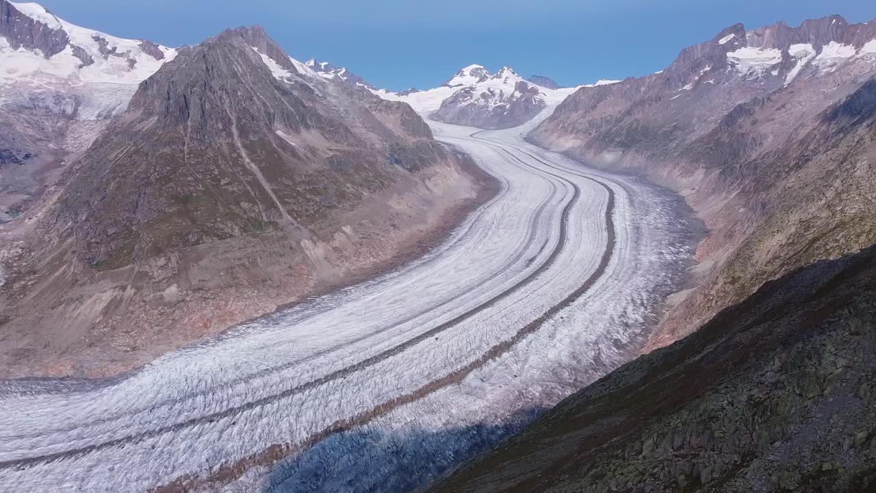 Aerial reveal view of the Aletsch Glacier inside the Swiss Alps. scenic mountain range, rocky landscape
