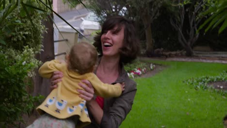 Caucasian-baby-running-to-woman-in-garden