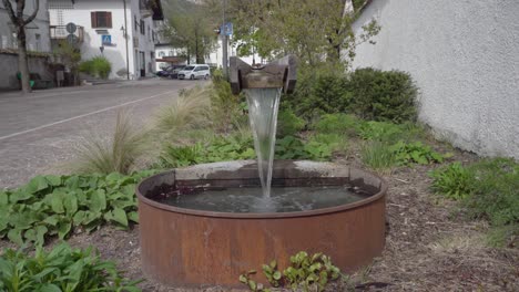 a modern design of a village fountain in kurtinig - cortina, south tyrol, italy