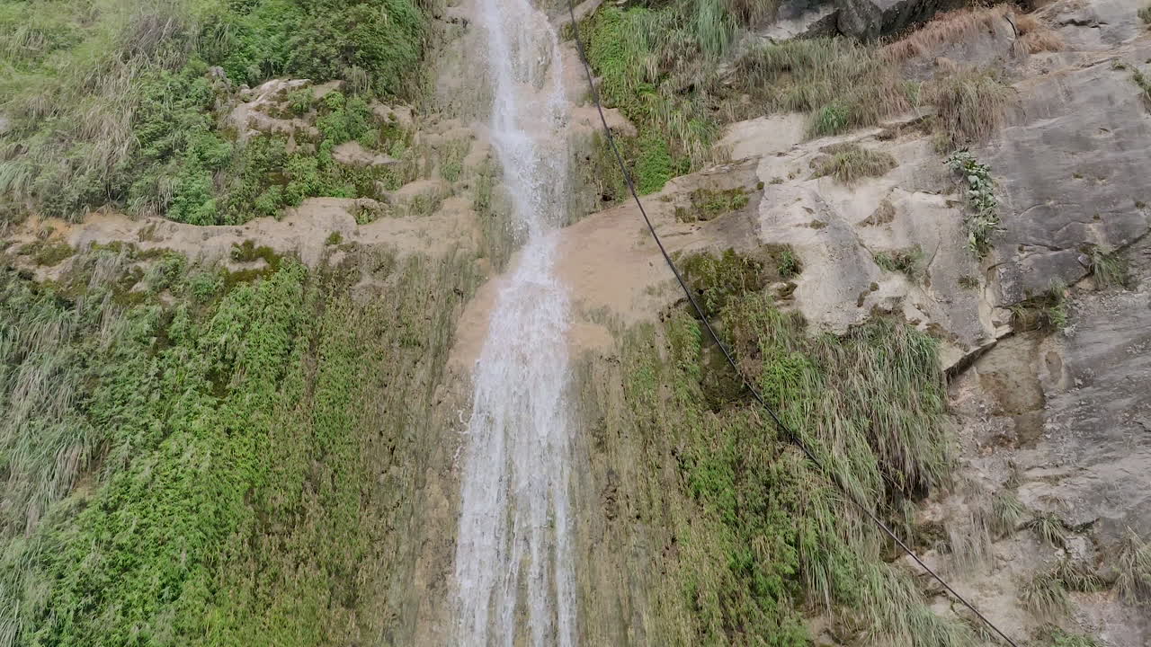 hermosa cascada natural cayendo por las colinas en la zona montañosa