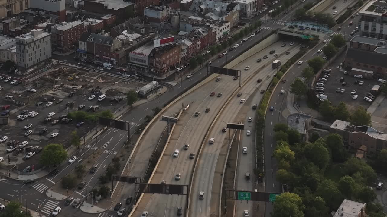 Drone view of busy highway in Philadelphia with urban buildings nearby