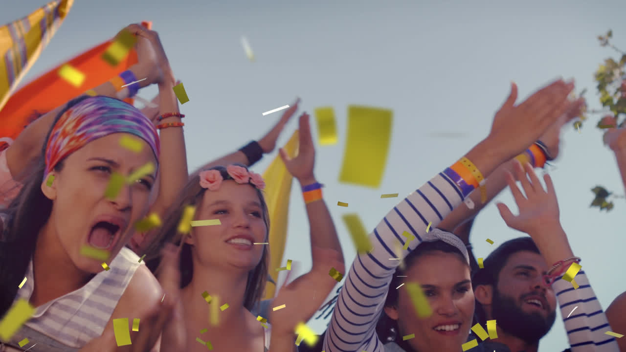 animación de confeti cayendo sobre personas bailando y animando durante un concierto de música