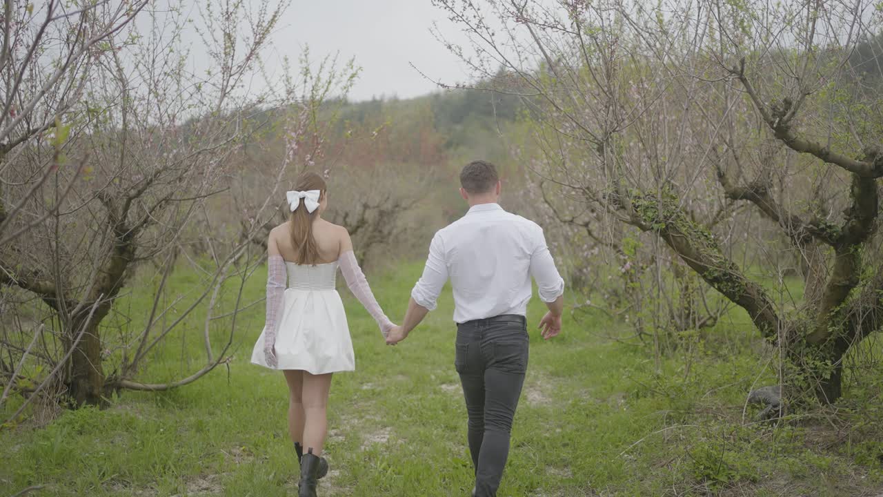 꽃이 피는 나무들 사이에서 손을 잡고 는 부부