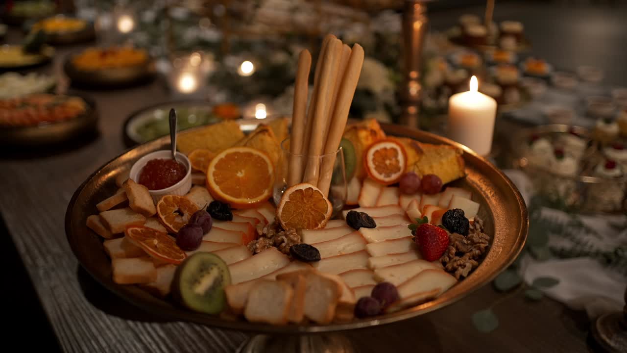 elegant cheese platter with fresh fruits breadsticks and jam on wedding table