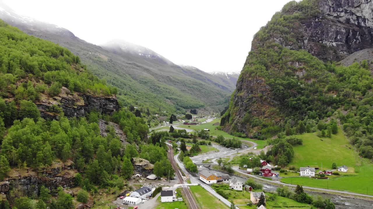 aérea: sobrevolando el valle de flåm entre montañas, ríos y verdes prados