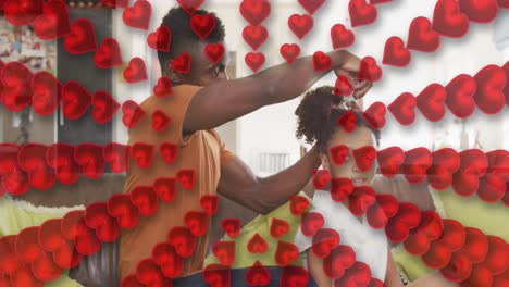 animación de corazones rojos sobre padre e hija afroamericanos