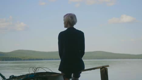 woman sitting by a lake