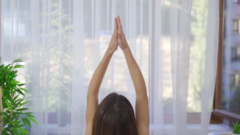 mujer joven meditando en casa.