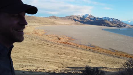 pov-walking-up-mountain-trail-to-reveal-mountains-and-hiker-holding-camera