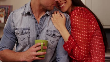 smiling couple hugging and drinking tea