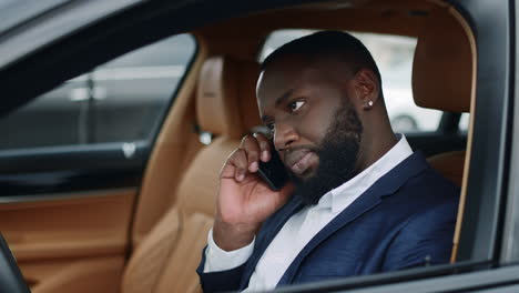 Primer-Hombre-Africano-Cogiendo-El-Teléfono-En-El-Coche.-Hombre-Hablando-Por-Teléfono-Inteligente-En-El-Coche