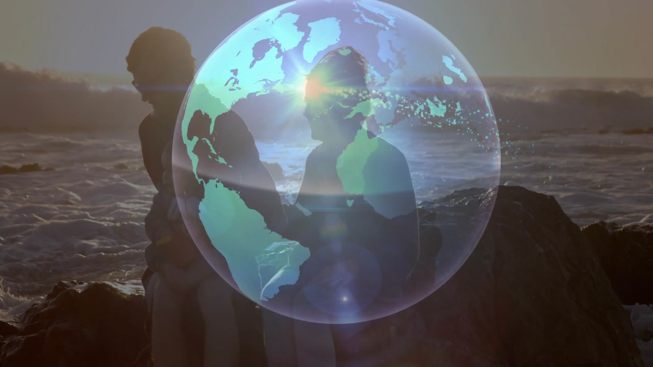Man and woman on rocks watching globe appearing, rotating, sparks centering over pair, linking tech
