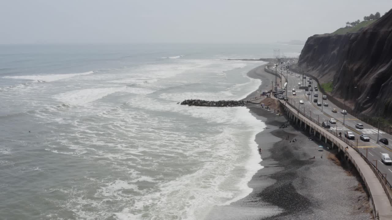 acantilado de la costa verde de miraflores, playa y carretera subiendo - drone uhd