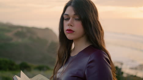 mujer posando sosteniendo un libro frente al cielo nublado al atardecer de cerca. modelo morena