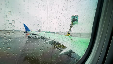 Punto-De-Vista-Del-Asiento-De-La-Ventana-Cuando-El-Avión-Tiene-Un-Ala-Rociada-Con-Líquido-Verde-Para-Descongelar